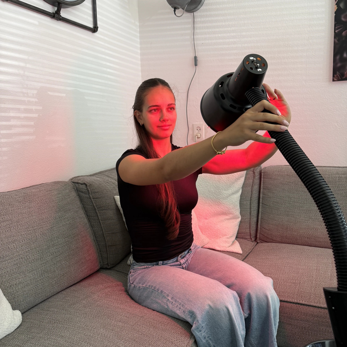 Woman adjusting the lamp head of the Redlight 160 infrared lamp by hand